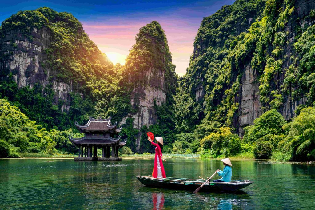 woman and a man on a canoe on a lake between mountains